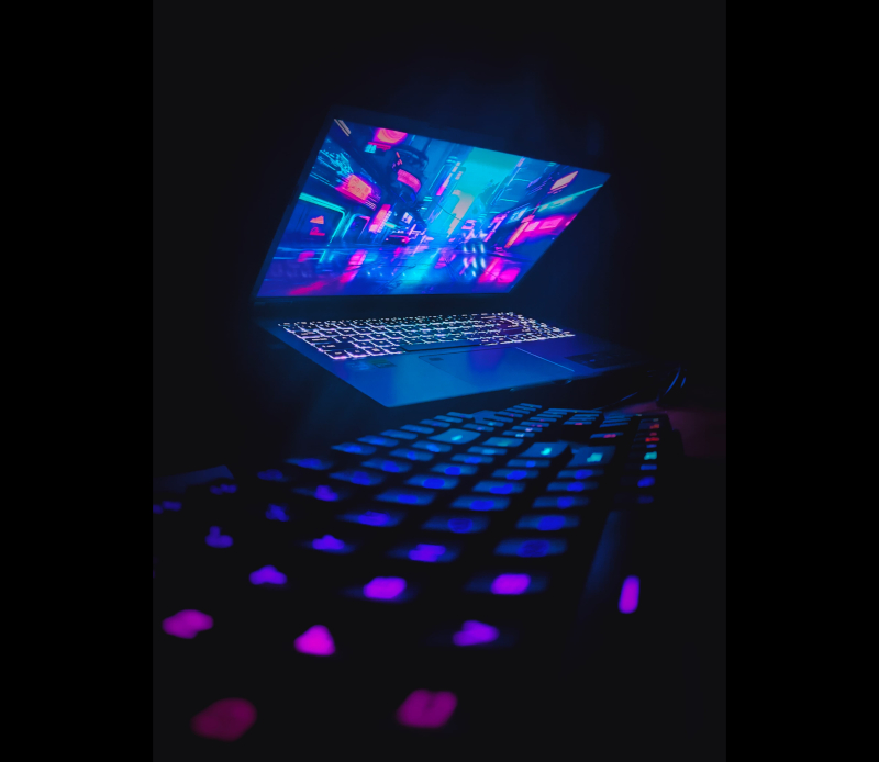 An image of a gaming laptop with a RGB gaming keyboard on a black background.