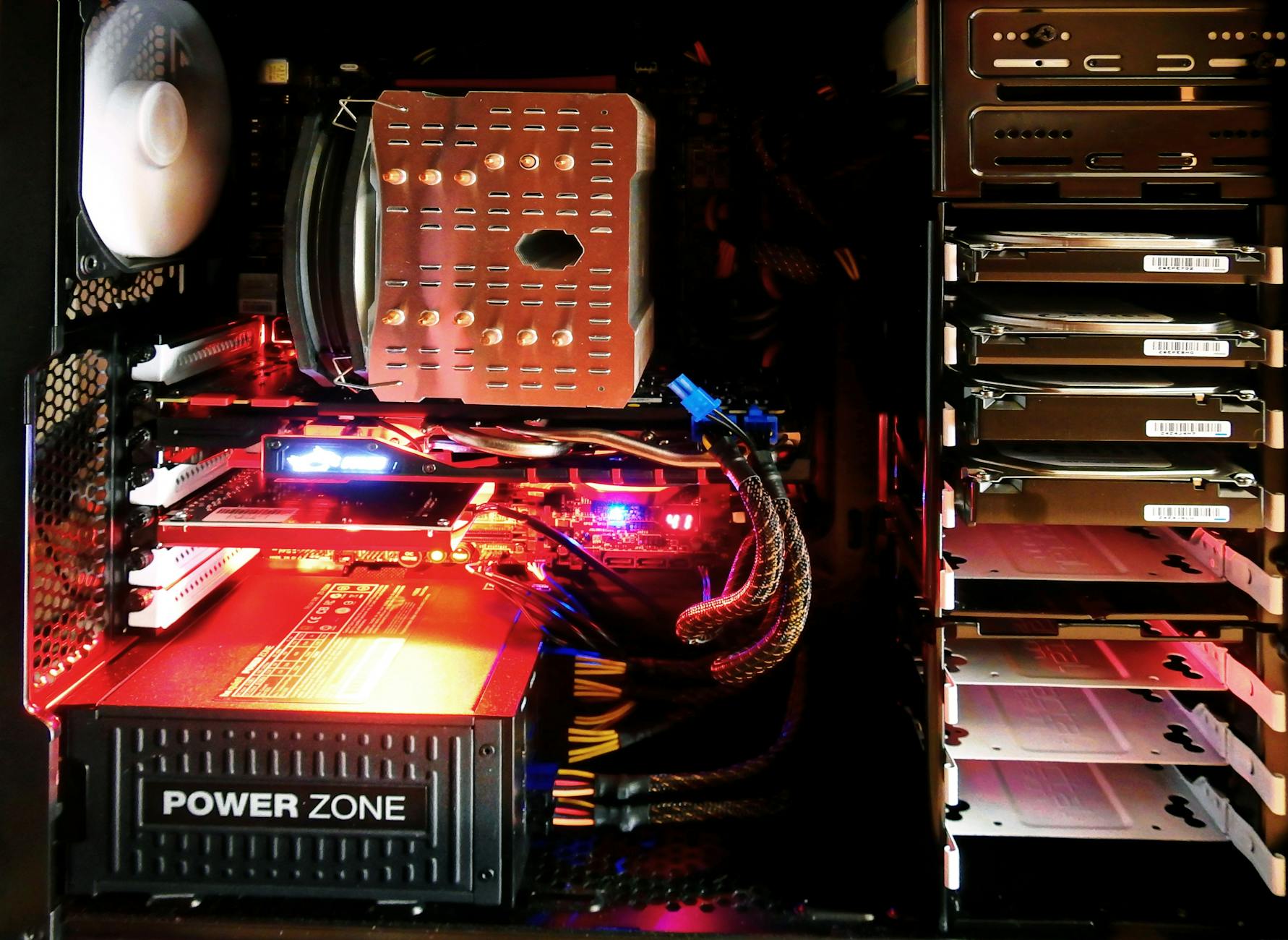 Picture of how an inside of a gaming rig looks with a bunch of RGB lights, RAM, power supply, motherboard and so on.