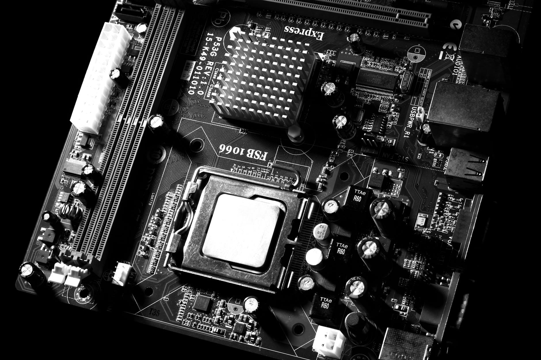 An image of a black coloured Motherboard with a CPU attached.
